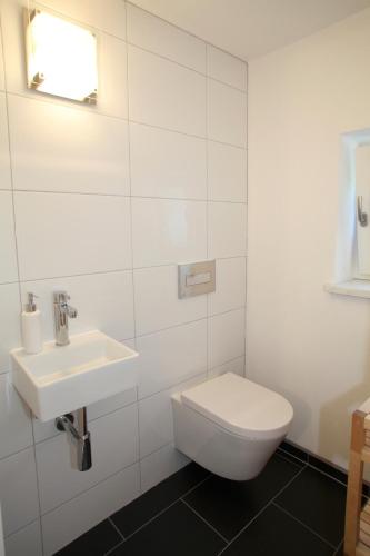 a white bathroom with a toilet and a sink at Landhaus Constantin Luxus-Appartments in Berchtesgaden