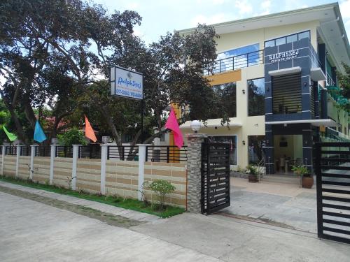 a building with a fence in front of it at Ralphseej Pension House in Moalboal