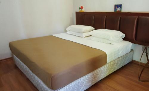uma cama com duas almofadas num quarto em the coconut langkawi em Pantai Cenang