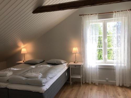 una camera da letto con un letto con due lampade e una finestra di Bjärkas Golf & Country Club a Nivelax
