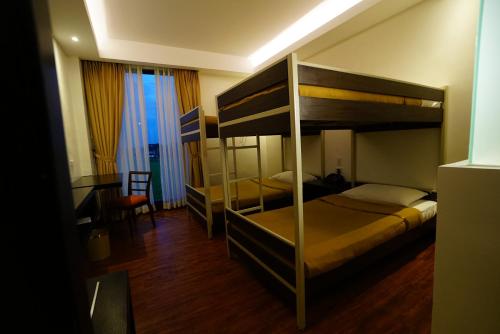 a bedroom with two bunk beds and a desk at Hotel Oazis in Butuan