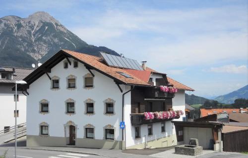 Un bâtiment blanc avec des fleurs sur son côté dans l'établissement Pension Schöpf, à Arzl im Pitztal