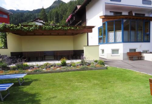 a house with a yard with benches in front of it at Pension Schöpf in Arzl im Pitztal