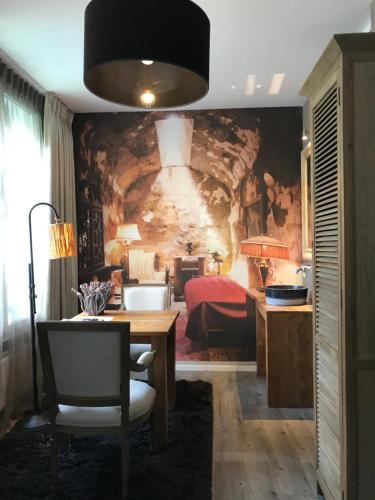 a bedroom with a stone wall with a table and a bed at Hotel Huis van Bewaring - Bijzonder boutique hotel in historisch pand in Almelo