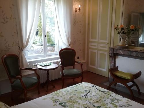 a room with chairs and a table and a window at Château des marronniers in Baizieux