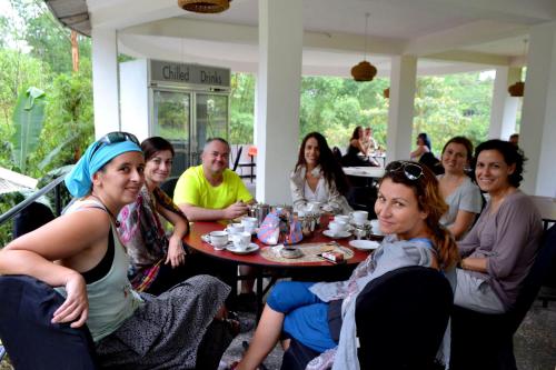 a group of people sitting around a table at White House Adam`s Peak in Nallathanniya