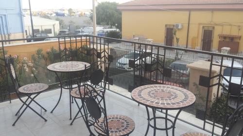 a balcony with tables and chairs on a balcony at Casa Vacanze LIBERTY in Licata
