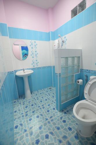 a blue and white bathroom with a toilet and sink at Sansook Chaolao in Chao Lao Beach