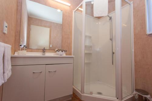 uma casa de banho com um chuveiro e um lavatório. em Motel Te Kuiti em Te Kuiti