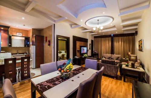 a living room with a dining table and a kitchen at Boudl Buraydah in Buraydah