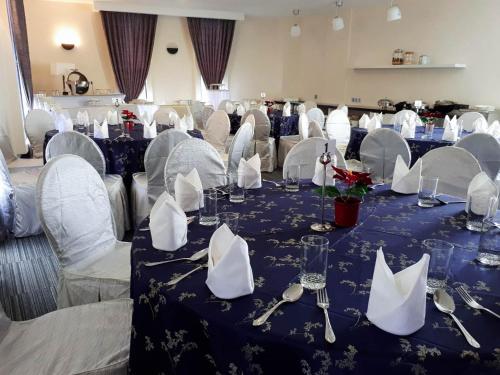 a room with tables and chairs with silverware on them at Bei Boutique Hotel in Muar