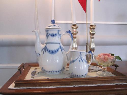 a table with a tea pot and vases on it at Hotel Postgaarden in Skælskør