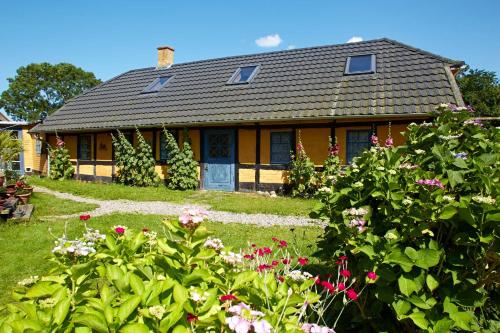 a house with a bunch of flowers in the yard at Møllegade 1 Holiday House in Nordborg
