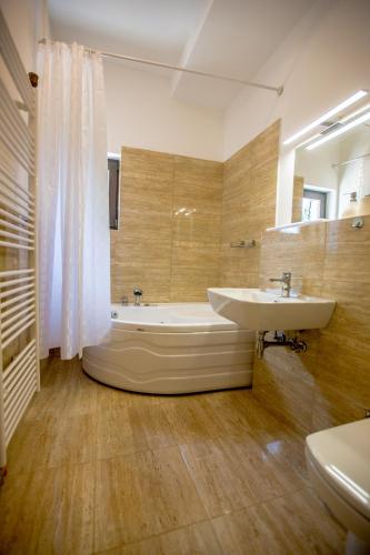 a bathroom with a sink and a tub and a toilet at Villa Glamour in Hadžići