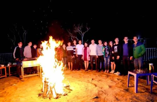 a group of people standing around a large fire at Dalat Topview Homestay in Da Lat
