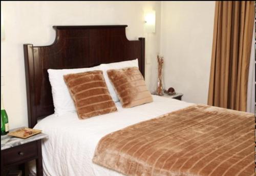 a bedroom with a large bed with two pillows at Hotel Palanca in Porto