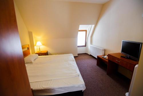 a hotel room with two beds and a flat screen tv at Residence Piata Sfatului in Braşov