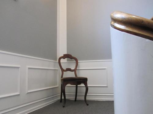 a chair sitting in the corner of a room at Hotel Postgaarden in Skælskør