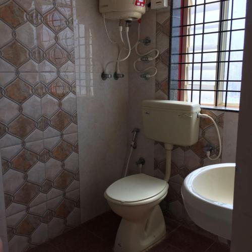 La salle de bains est pourvue de toilettes et d'un lavabo. dans l'établissement Marina Stay, à Chikmagalur