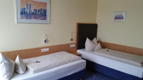 two beds in a hotel room next to each other at Hotel Ifen in Wiesloch