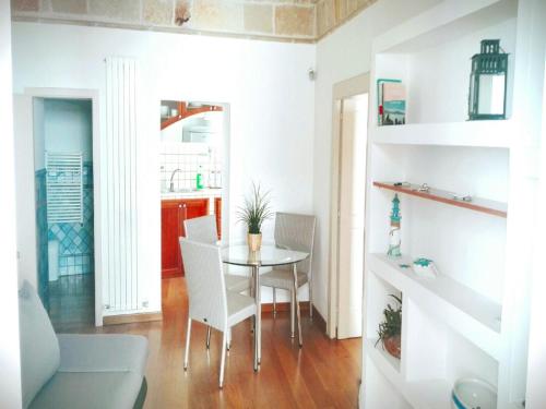 a dining room with a table and white chairs at Brezza Marina in Polignano a Mare