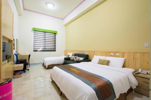 a hotel room with two beds and a tv at Emilia Resort I in Hengchun