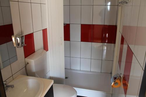 La salle de bains est pourvue de toilettes, d'un lavabo et d'une douche. dans l'établissement Complex HAMAK, à Iaşi
