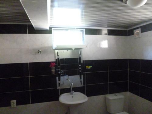 a bathroom with a sink and a toilet and a window at Guest House Gabo in Mestia