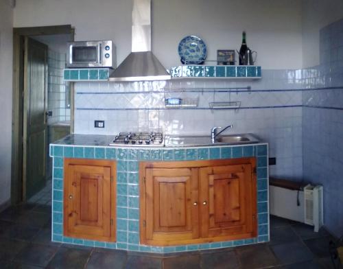a kitchen with a sink and a stove at Cottage Fuile 'E Mare in Orosei