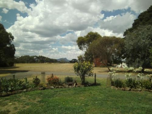 un patio con un estanque y un campo con árboles en Grampians Historic Homestead B&B, en Moutajup