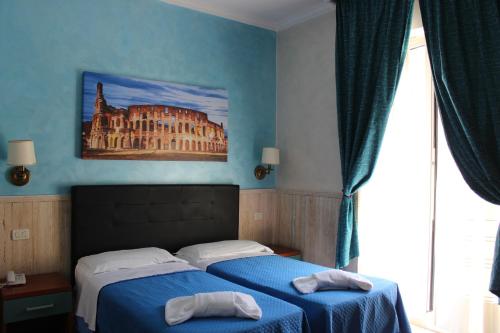 una camera con due letti e un dipinto di un edificio di Hotel Pyramid a Roma