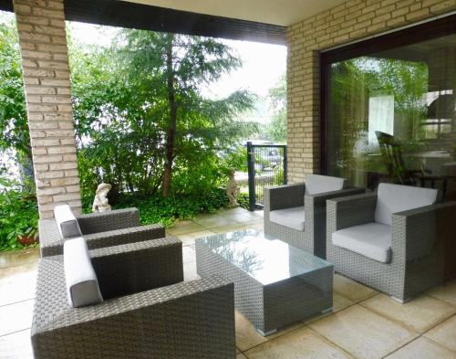 a patio with couches and a table and chairs at Haus Kranenborgh im Mühlenspiegel Steinhude am Meer in Steinhude