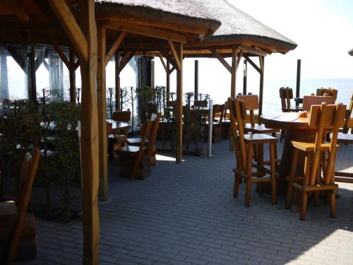 a restaurant with tables and chairs and a roof at Ferienhaus Hendrikje in Kamminke