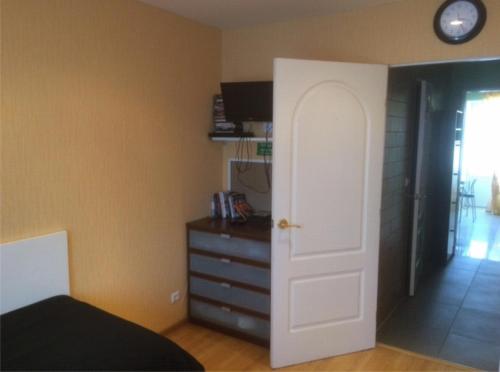 a bedroom with a bed and a dresser and a door at Apartment on Oktyabrskaya 21 in Belomorsk