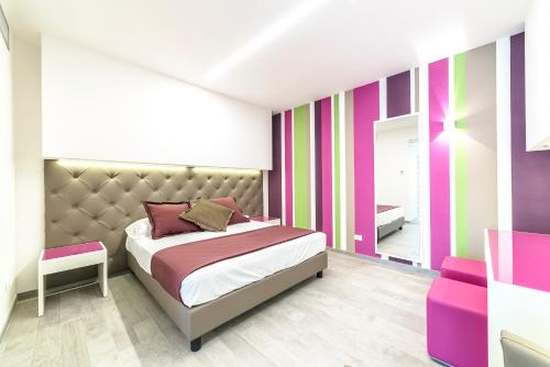 1 dormitorio con 1 cama y una pared colorida en Hotel Tenda Rossa en Marina di Carrara