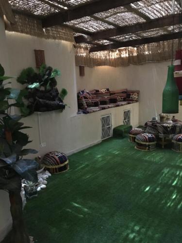 a room with a green floor with chairs and a table at Sporting Suite Studio in Alexandria