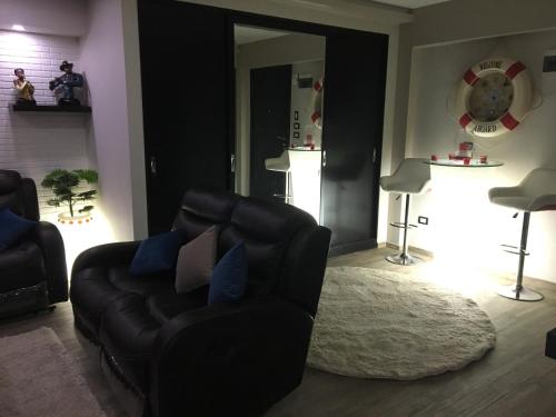 a living room with a black couch and a rug at Sporting Suite Studio in Alexandria