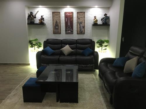 a living room with a black couch and a table at Sporting Suite Studio in Alexandria