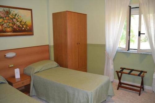 a bedroom with two beds and a cabinet and a window at Yellow Park Hotel in Forchia