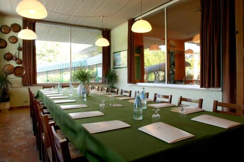 a long table in a restaurant with a green table cloth at Hotel Country Club in Capannori