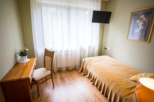 a bedroom with a bed and a desk and a window at Irbēni in Brivkalni