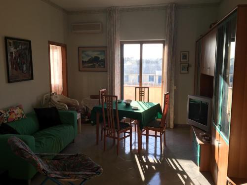 カラベルナルドにあるCasa vacanze Maria Graziaのリビングルーム(緑のテーブル、椅子付)