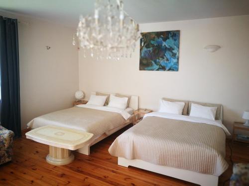 two beds in a room with a chandelier at Irena Family House in Vilnius