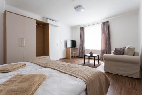 ein Schlafzimmer mit einem großen Bett und einem Sofa in der Unterkunft Zehentner - Wein & Feriendomizil in Illmitz