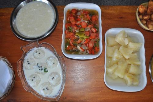 a table with two trays of food with potatoes and vegetables at Villa Cayana in Barra Grande