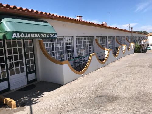 a building with a green awning on the side of it at Residêncial Colaço in Alcoentre