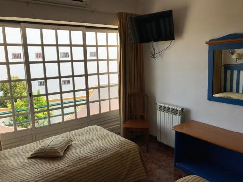 a bedroom with a bed and a large window at Residêncial Colaço in Alcoentre