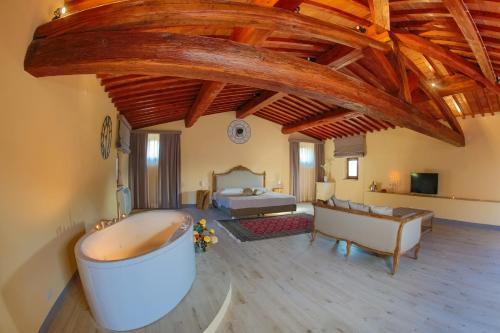 a large room with a bath tub and a bed at Relais Villa Poschi in Pugnano