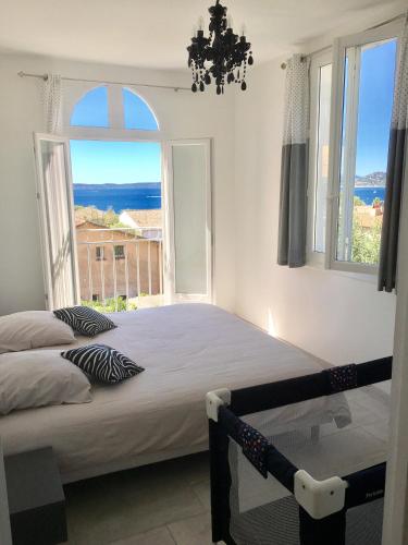 une chambre avec deux lits et une grande fenêtre dans l'établissement Appartement avec splendide vue mer, à 200 m de la plage, Golfe de Saint-Tropez, aux Issambres