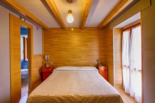 um quarto com uma cama num quarto com paredes de madeira em Albergo Speranza em Asiago